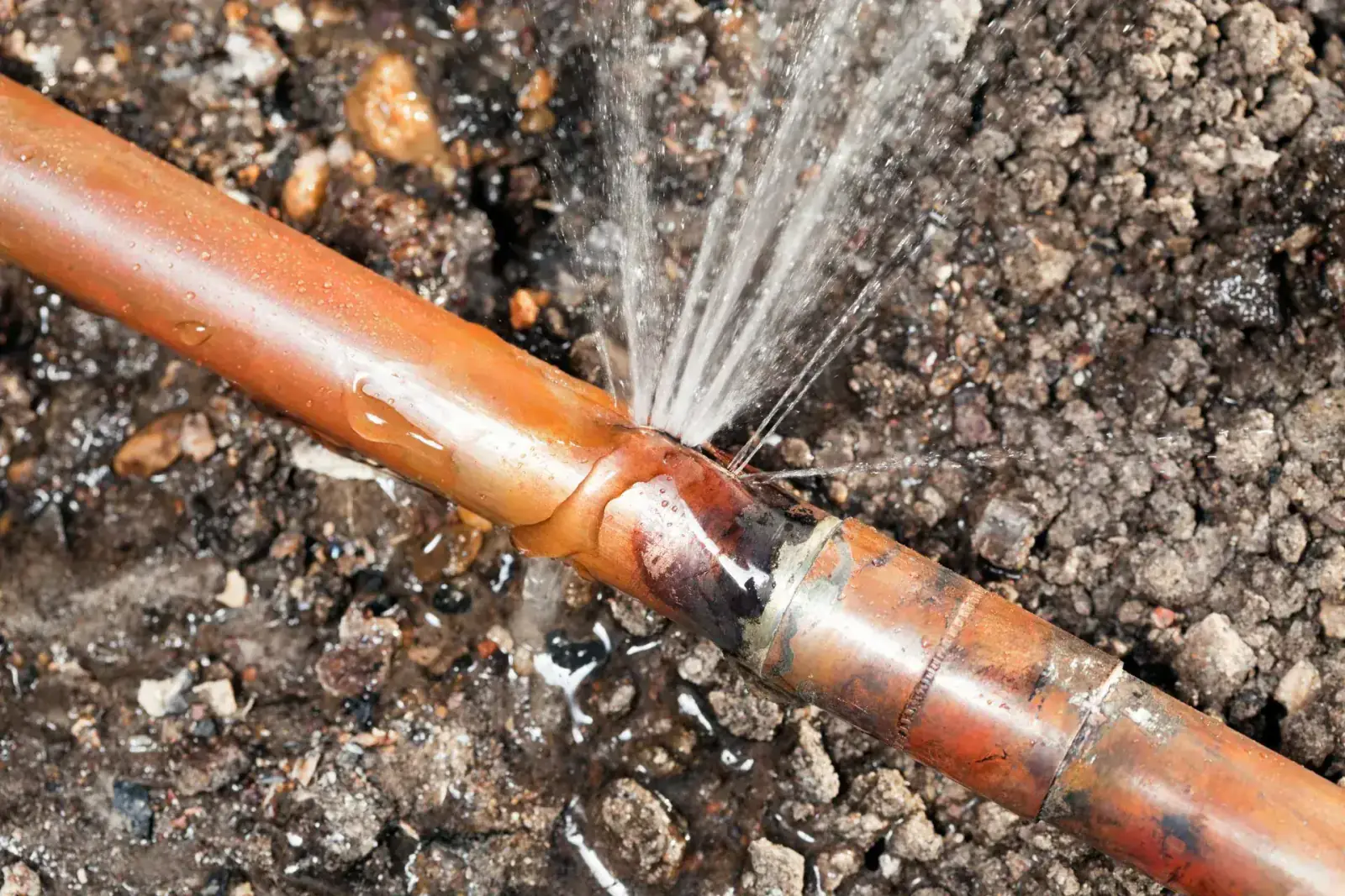 Water spraying from a split in a buried copper water line